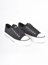 Zapatillas de plataforma estilo urbano, color negro con puntera y suela de goma blanca. Cuentan con cordones negros y ojales metálicos.
