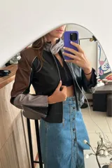 Campera tipo moto con cuello mao en platino suave y combinación de tres tonos de cuero ovino: negro, marrón rojizo y plateado. Forrada con cierres en las mangas.