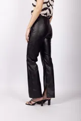 Pantalón negro de cuero sintético, corte flare y tiro medio.