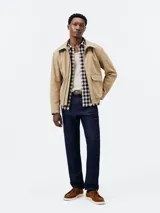 Pantalón de jean azul, corte slim fit, con cierre de botón y cremallera.