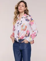 Camisa de gasa blanca con estampado floral multicolor, cuello con solapa, mangas largas y cierre frontal con botones. Cuenta con terminación delantera anudada y espalda más larga.