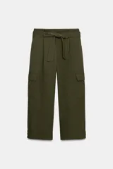 Pantalón cargo de tiro medio en color verde militar. Presenta bolsillos laterales con solapa, cierre frontal con cremallera y gancho metálico, y un cinturón ajustable del mismo tejido. El bajo incluye trabillas con botón.