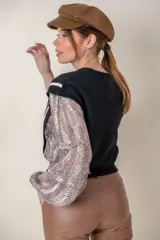 Buzo negro de lana fina con mangas largas abullonadas y laterales de seda con estampado animal print.