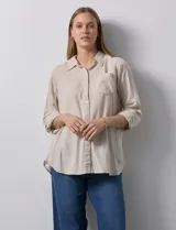 Camisa de lino color beige de la marca Dash, con cuello camisero, cierre frontal con botones, manga larga regulable con presilla y un bolsillo aplicado en el pecho.