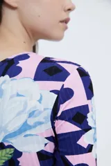 Vestido corto de mangas largas, con fit entallado, realizado en morley estampado con print geométrico que combina flores y patrones geométricos.