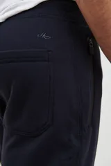 Pantalón jogging de corte slim, con puños elastizados, cintura con cordón ajustable, cierres laterales engomados y bolsillo tipo parche lateral.