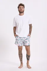 Short de baño rosado con estampado de flores grandes en tonos celestes y amarillos, con cintura elástica y cordón ajustable.