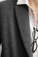 Abrigo de corte regular fit confeccionado en tejido compacto con mezcla de lana. Presenta cuello con solapas de muesca, cierre frontal de botonadura, bolsillos de vivo en la cadera y abertura central en la espalda.