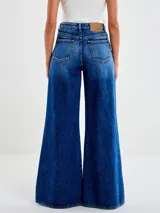 Jeans de mezclilla azul oscuro, tiro alto, con corte palazzo de pierna muy ancha y efecto degradado en las bastas.
