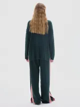 Buzo tejido de punto color beige, con cuello subido, diseño oversized y aberturas laterales en el ruedo.