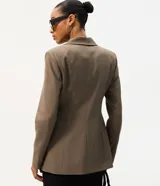 Blazer de sastrería ajustado color marrón, con cuello de solapa clásica, cierre frontal de un botón y bolsillos delanteros con solapa.