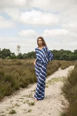 Pantalón de piernas anchas con estampado de rayas diagonales en azul y blanco. Elástico en la cintura con tirantes para anudar y bolsillos laterales.