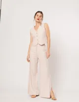 Pantalón negro de lino, tiro alto, corte palazo, con elástico en la pretina trasera, cierre delantero y broche interno. Tiene bolsillos laterales, dobladillo invisible y tajos a los costados.