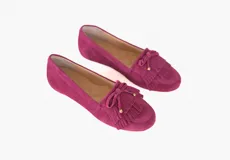 Mocasines de cuero gamuzado color fucsia, con flecos y un lazo con herrajes metálicos dorados en la capellada. Suela plana de goma.