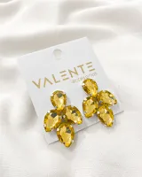 Aros colgantes con forma de flor, con gemas facetadas color amarillo engarzadas en metal plateado.