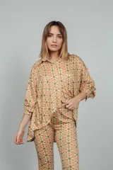 Camisa de manga larga color rosado con estampado de flores anaranjadas y blancas.