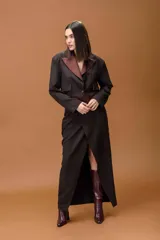 Falda de corte sastrero en color negro con detalles en contraste color bordó en la cintura, laterales y bolsillos traseros. Presenta una cintura alta con ajuste lateral mediante hebilla metálica.