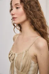 Vestido largo negro de algodón, con breteles finos, escote con frunce y lazo regulable. Tiene cintura definida y falda amplia escalonada, con detalles bordados verticales en contraste.