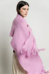 Bufanda de gran tamaño en color rosa, confeccionada en tejido de punto con textura y terminación en flecos en los extremos.