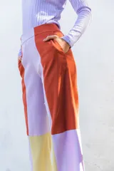 Pantalón de corte recto con diseño color block en tonos naranja, turquesa y beige. Presenta cintura alta y bolsillos laterales.