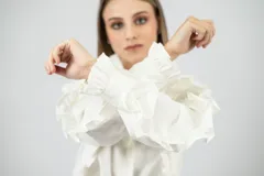 Camisa blanca de cuello mao con volados, mangas largas con puños ajustados y corte clásico.