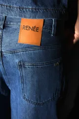 Pantalón jean azul denim de tiro medio, corte oversize y bolsillos cargo laterales y delanteros.