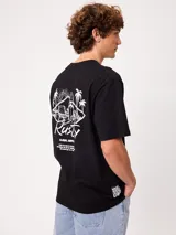 Remera blanca Rusty de corte holgado, con cuello redondo y mangas cortas. Presenta un estampado en la espalda de estilo veraniego con palmeras, una tabla de surf y letras alusivas a la marca.