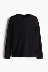 Remera de manga larga en tejido de punto waffle, con cuello redondo y puños acanalados. Presenta un corte ajustado al cuerpo.