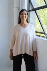 Sweater de punto en color crudo, con escote en V, mangas tres cuartos con puños acanalados y diseño holgado.