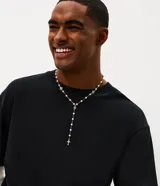 Collar de metal estilo rosario para hombre, con cuentas de perlas sintéticas, detalles de flores y un dije colgante en forma de cruz.