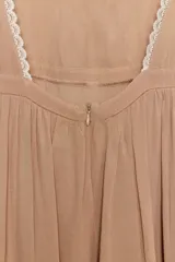 Vestido corto color tostado con escote cuadrado y mangas cortas. Presenta detalles de encaje en contraste en el escote y los bordes de las mangas. Cuenta con espalda descubierta y cierre posterior con cremallera oculta.