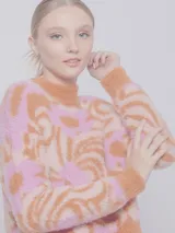 Sweater de punto color naranja y rosa con diseño de jacquard, textura peludita, manga larga y cuello alto.