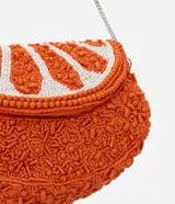 Cartera tipo hobo con diseño creativo en forma de rodaja de naranja, confeccionada con abalorios texturizados en tonos naranja y blanco. Cuenta con una correa de cadena metálica fina para llevar de forma transversal y cierre de tapa.