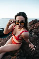 Conjunto de bikini rojo con hebillas metálicas plateadas y bombacha colaless.