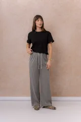 Pantalón de calce amplio y relajado, confeccionado en Tencel de pierna ancha, con cintura elástica y cordón ajustable.
