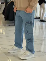 Pantalón cargo de jean azul claro, con corte oversize y múltiples bolsillos laterales en las piernas.
