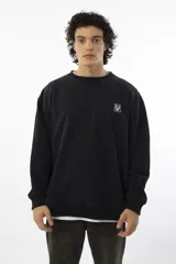 Buzo negro de corte oversize con logo bordado en el pecho.