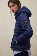 Campera puffer con capucha, color verde, diseño acolchado con costuras horizontales y cierre frontal.