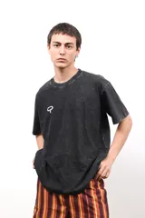 Remera negra de algodón con efecto acid wash, con estampado de girasol en la espalda y la palabra "CAPER." en blanco.