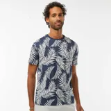 Camiseta de manga corta azul con estampado de hojas de palmera blancas.