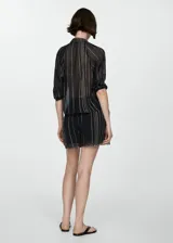 Short de corte recto con diseño de rayas verticales en tonos oscuros con detalles en lila y amarillo. Presenta bajo deshilachado y cintura elástica con cierre de lazo.