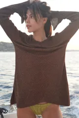 Blusa de punto larga color rojo con destellos dorados, manga larga, escote bote y pequeñas aberturas en los laterales y puños.