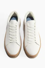 Championes blancos con collarín acolchado, lengüeta y cierre de cordones. Forro y plantillas en lona de algodón. Suelas texturizadas con diseño y grosor de 3,9 cm.
