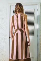 Vestido midi sin mangas, con escote en V y detalle de lazada frontal. Presenta un diseño de rayas verticales en tonos rosado y marrón, con un panel inferior de rayas horizontales.