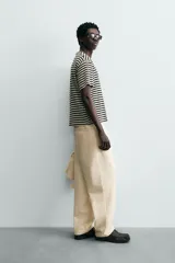 Camiseta de manga corta con cuello redondo y calce relajado, confeccionada en tejido de rayas horizontales blancas y negras.