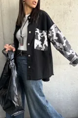 Sobrecamisa negra con mangas estampadas con diseño de vaca.