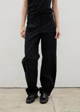 Pantalón de gabardina con corte barrel, diseño holgado y tiro medio. Cuenta con cierre frontal y bolsillos laterales.