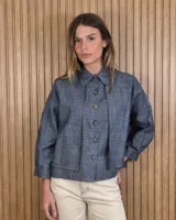 Sobrecamisa de lino en color gris con textura sutil, diseño de corte holgado, mangas largas y bolsillos frontales con solapa. Cuenta con cierre frontal de botones y cuello camisero.