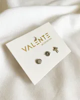 Set de tres pares de aros de acero quirúrgico plateado con cierre a presión. Incluye un par con forma de ojo turco, un par con forma de cruz y un par con un cristal engarzado.