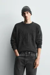 Jersey de corte relajado confeccionado en tejido de algodón con efecto lavado. Presenta cuello redondo, manga larga, acabados en rib y un bordado a tono en el delantero con diseño abstracto.